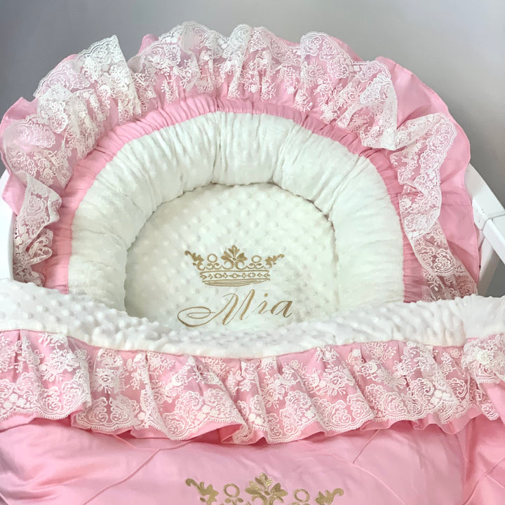 Pink and white baby nest with white lace details and gold 'Mia' embroidery.