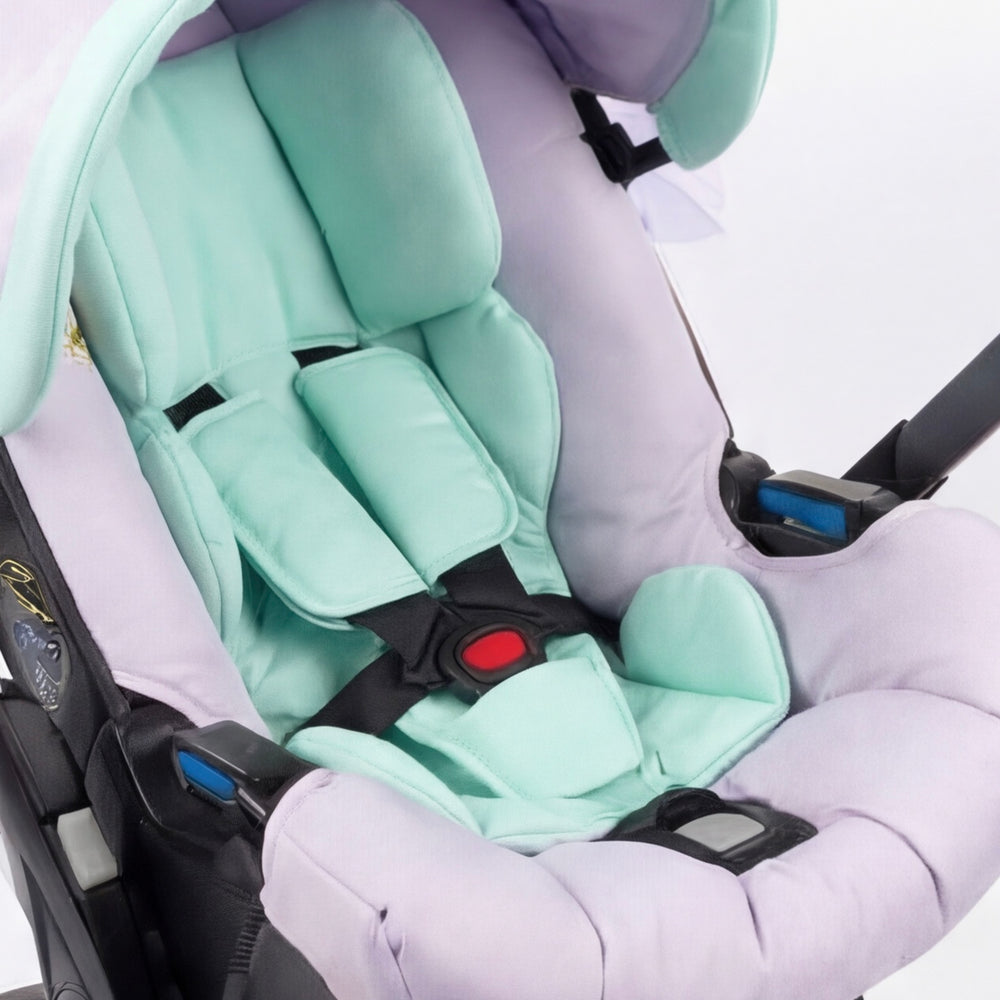 Close-up of a satin infant insert in mint and lavender tones, featuring smooth, non-pile fabric and ergonomic padding for newborn support inside a baby car seat, photographed on a white background.