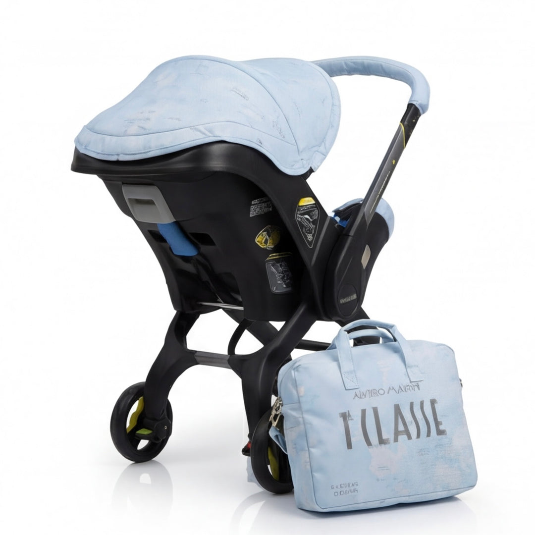 Rear left angled view of Doona Plus car seat featuring light blue world map cover set and matching diaper bag with personalized embroidery.