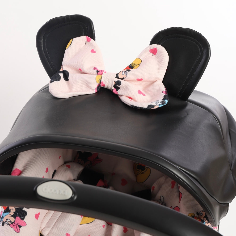 Black faux leather car seat canopy with decorative fabric ears and bow in pink cartoon print, coordinated with matching seat cover