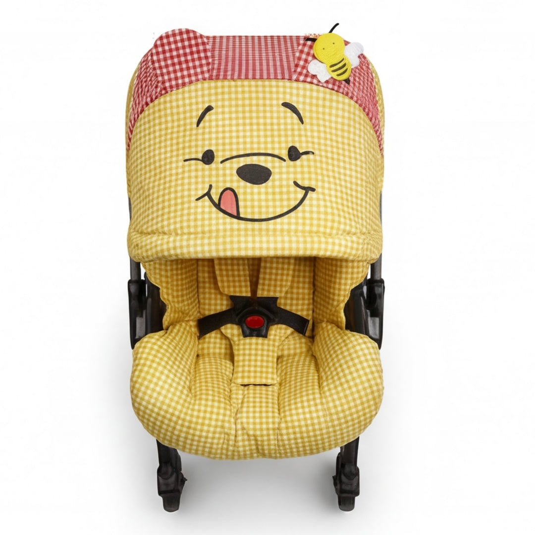 Doona+ yellow gingham car seat cover set with embroidered bear canopy and bee fabric applique, full front view.
