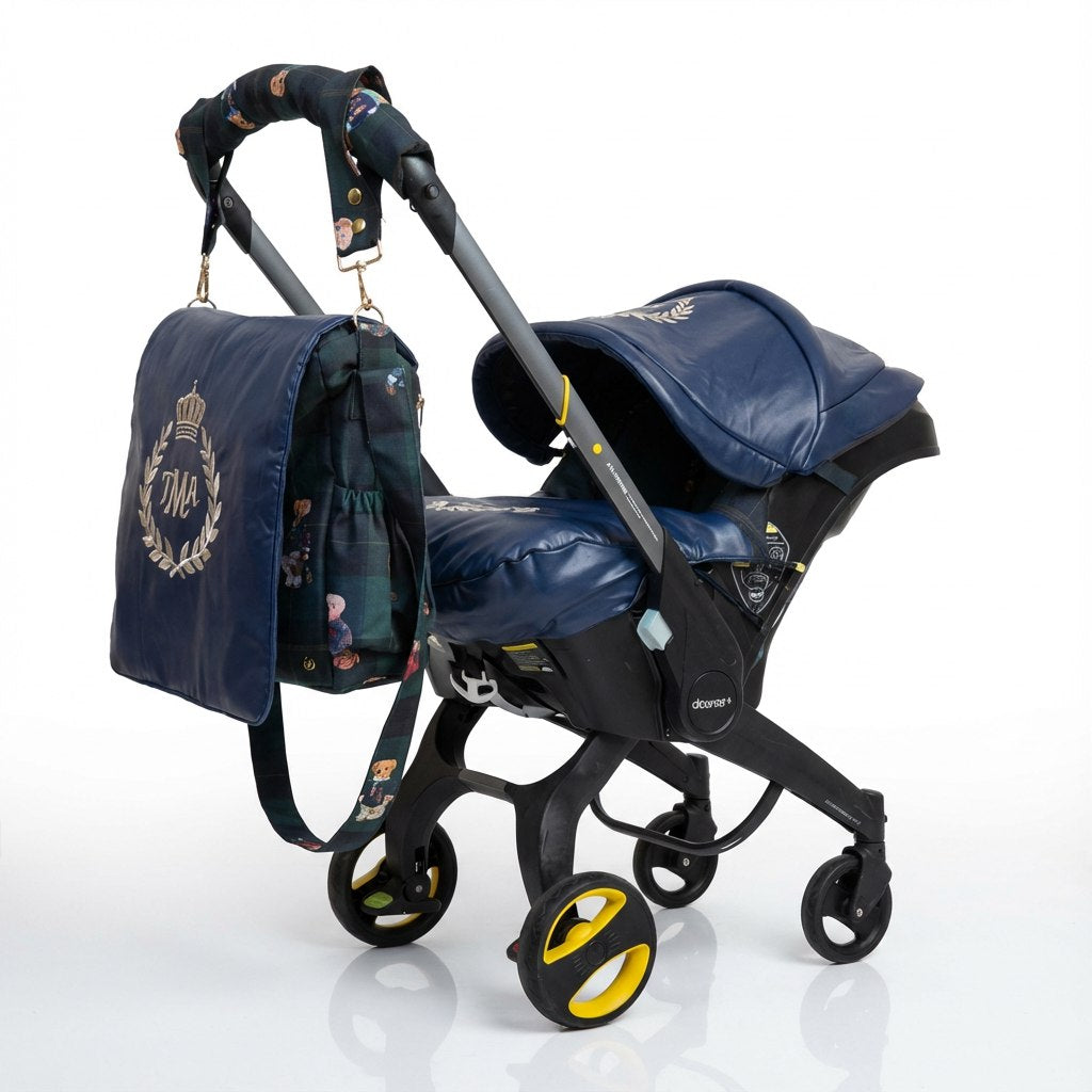 Side view of a Doona car seat. The canopy, footmuff, and front panel of the diaper bag are made of dark blue leather. The interior features a Polo-style teddy bear print. A matching dark blue diaper bag with a gold laurel wreath and crown monogram hangs from the handle. Shown on a plain light background.