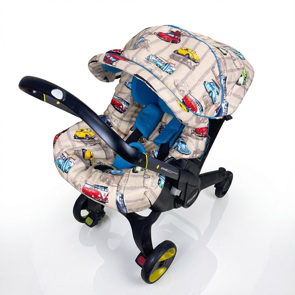 Front-facing baby car seat cover set installed on a car seat, featuring a retro vehicle print with classic Volkswagen Beetles and vintage minibuses in red, yellow, and blue on a beige background. The set includes a matching canopy and padded seat cover with blue inner padding, displayed on a white background.