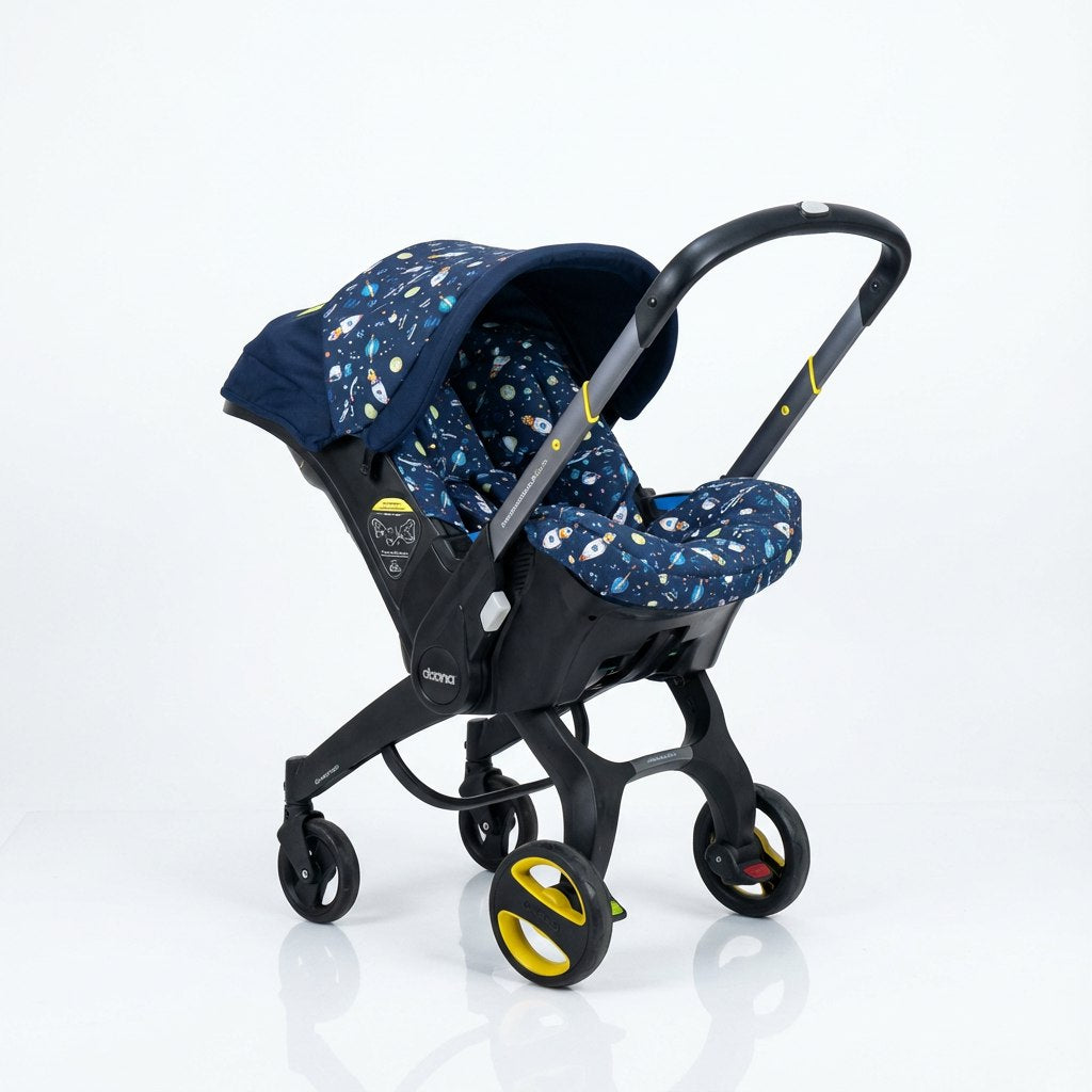 Baby car seat cover set installed on a car seat, shown at a side angle on a white background. The canopy and seat cover feature a dark blue space-themed print with rockets, planets, and stars. The deep navy base is complemented by small colorful cosmic elements, creating a playful yet modern look.
