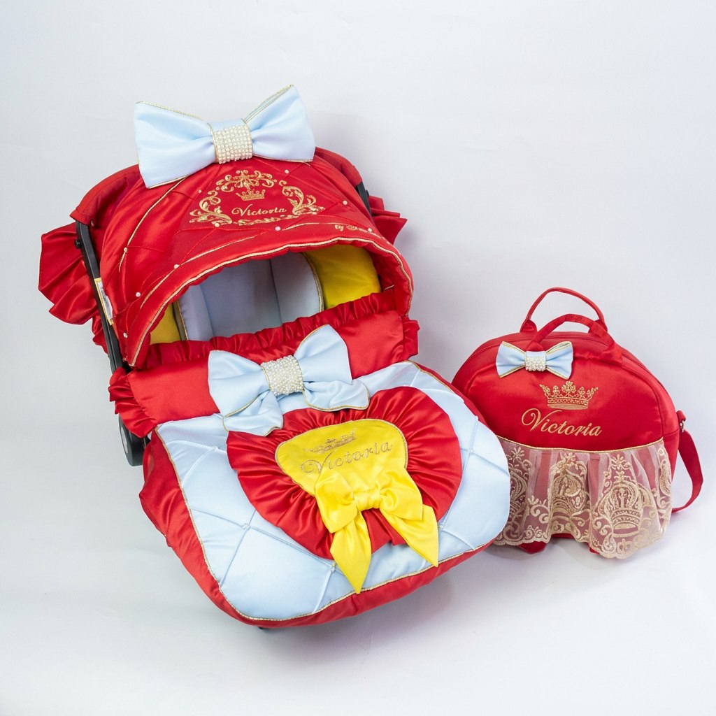 Red and light‑blue car seat cover set with satin quilting, gold personalized embroidery, blue bows with pearl centers and yellow bow; white studio background.