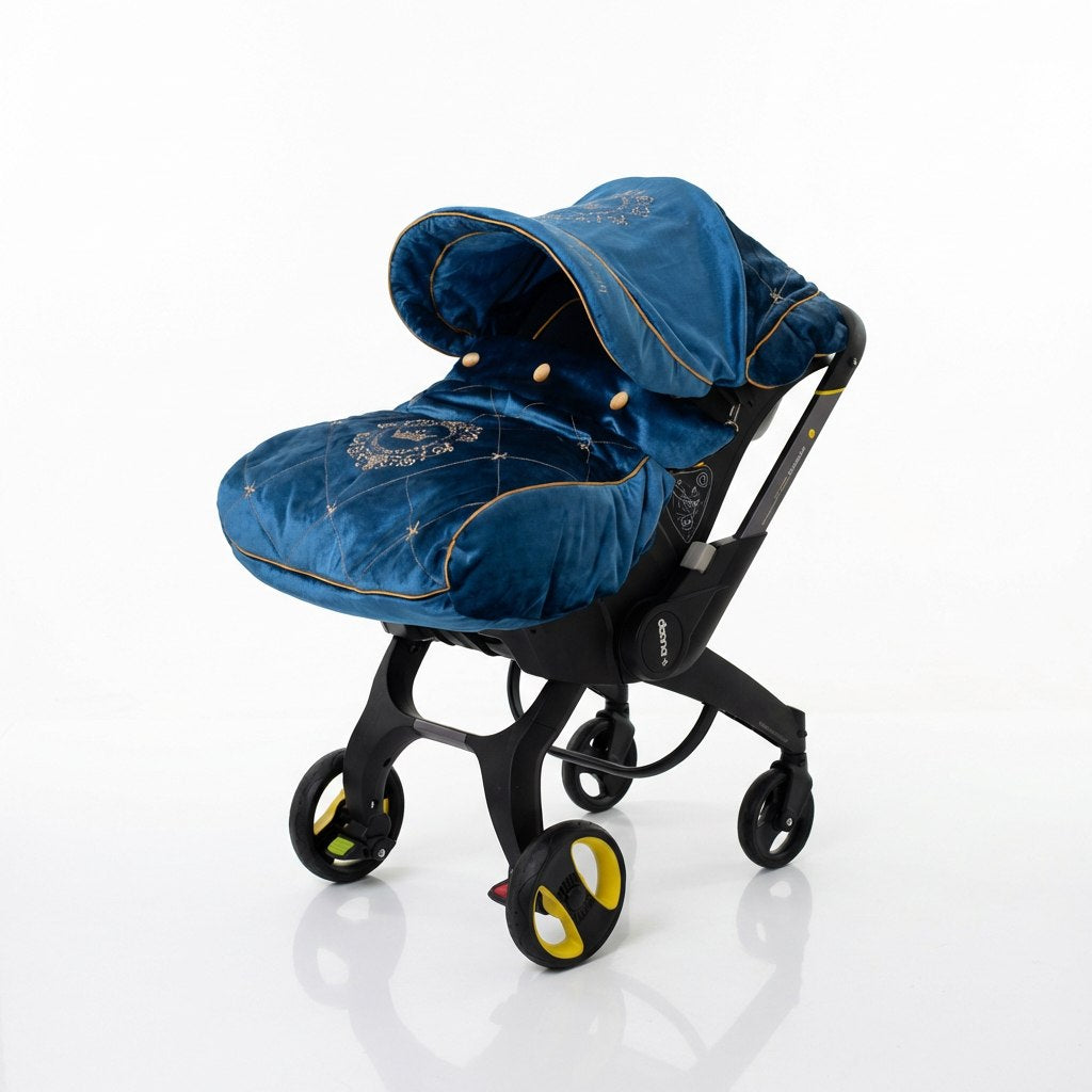 Luxury blue velour baby car seat cover set with gold embroidery details and gold piping, installed on a Doona car seat and photographed in a bright, minimal interior.