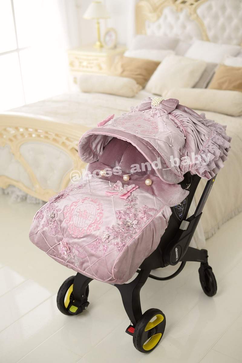 Customizable little girl's Doona stroller car seat with soft, stylish covers & accessories - Perfect for infant comfort, protection, and essential baby gear