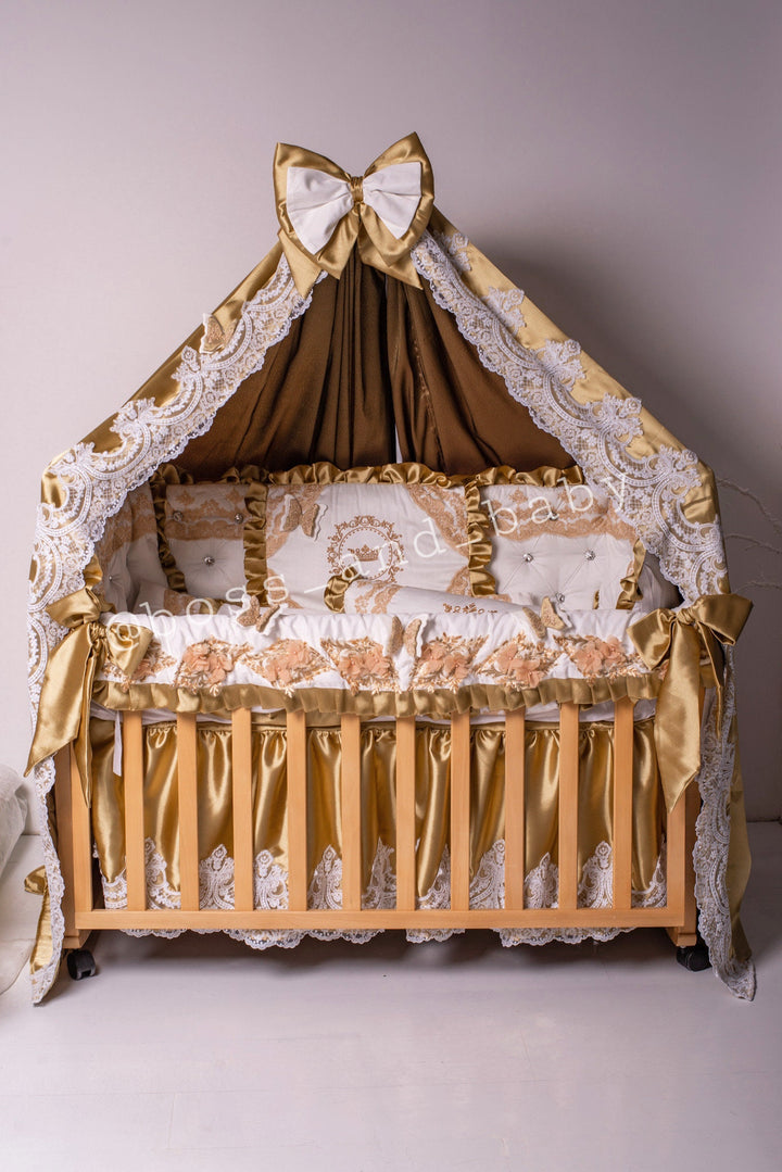 Offrez à votre petit prince le traitement royal avec notre parure de lit dorée pour bébé garçon ornée de dentelle française, de strass, de papillons et de broderies.